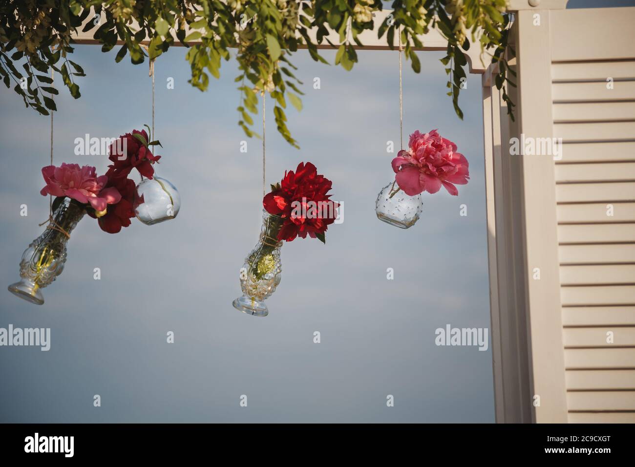 Décoration florale originale sous forme de mini vases et bouquets de fleurs accrochés à l'autel de mariage, cérémonie de mariage sur la plage extérieure Banque D'Images