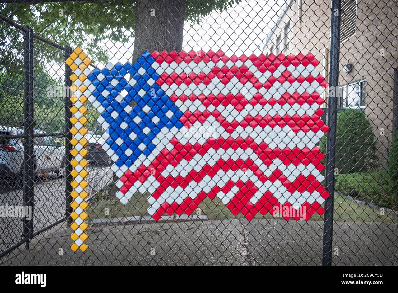 Un drapeau américain inhabituel fait de carrés qui ont été installés dans la clôture de chaînette. À l'école secondaire Holy Cross de Flushing, Queens, New York. Banque D'Images