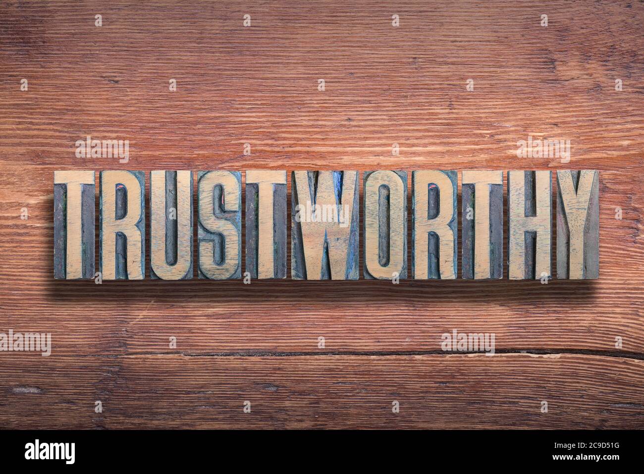 mot digne de confiance combiné sur une surface en bois verni vintage Banque D'Images
