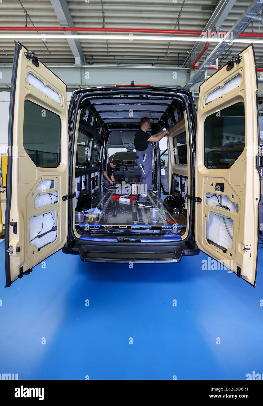 16 juillet 2020, Saxe, Plauen: Deux employés du MAN bus modification Center (BMC) modernisent un minibus électrique eTGE avec une garniture intérieure spéciale pour le transport de passagers. L'éclairage d'ambiance rouge ou bleu crée une atmosphère chaude ou froide et contribue ainsi à réduire la quantité d'air conditionné requise de deux degrés. Dans un véhicule électrique, cela a un effet direct sur la gamme. MAN, le carrossier-constructeur de bus basé à Plauen, se penche positivement sur les mois à venir après une baisse des ventes pendant la crise corona et la menace de coupures d'emplois dans l'entreprise. Grâce à l'accent mis sur la mobilité électrique et Banque D'Images