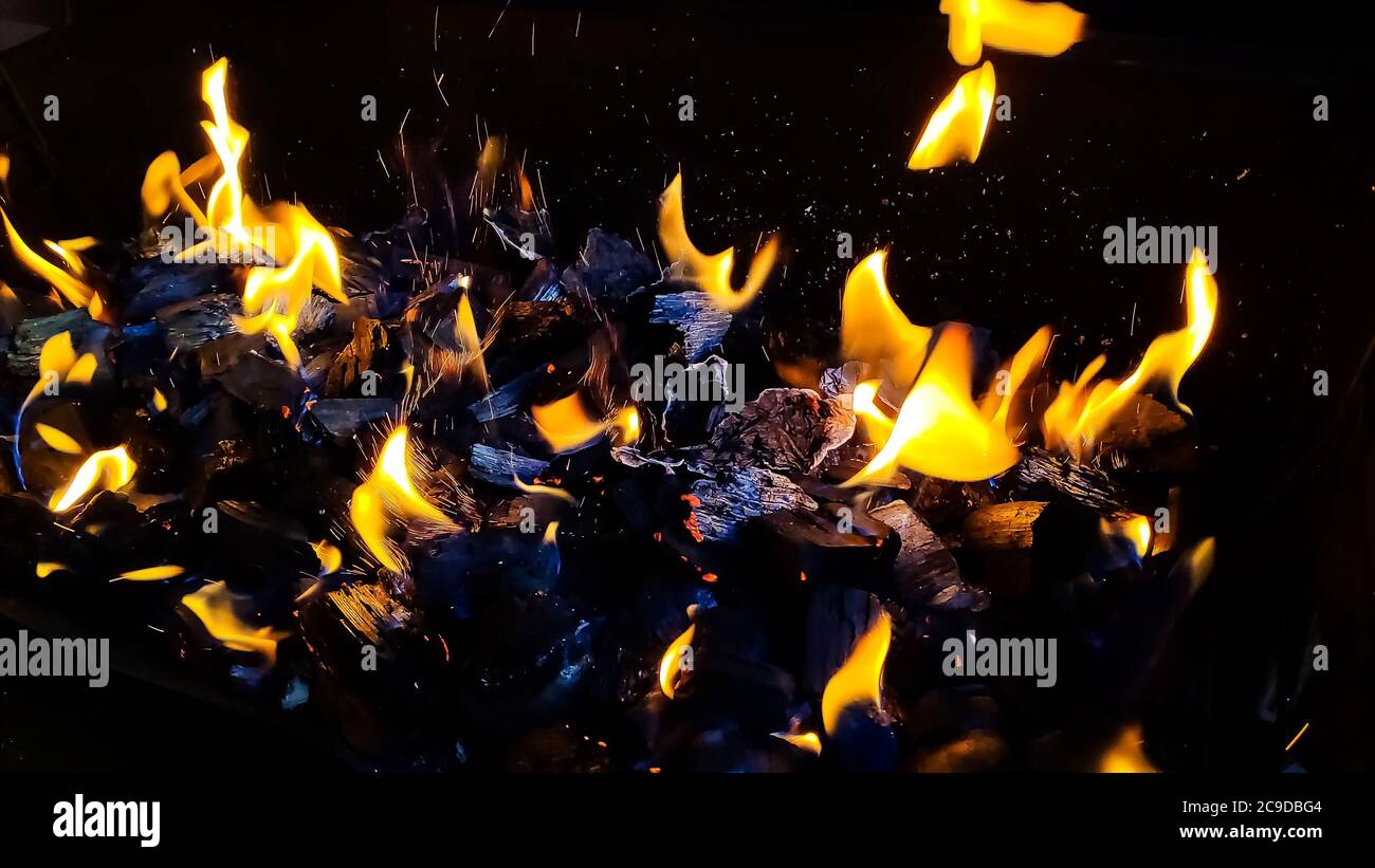 Charbons chauds dans le feu.brumeuses actives embres de feu.brûlants bois de chauffage dans la cheminée proche, feu de barbecue.noir brûlé charbon Banque D'Images