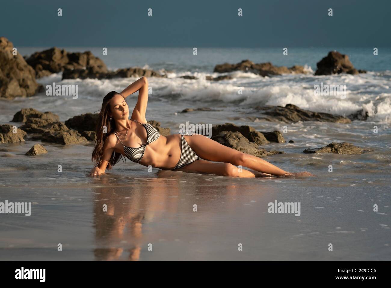 Jeune femme attrayante appréciant le dernier soleil raies sur un plage sur la côte mexicaine juste avant le coucher du soleil Banque D'Images