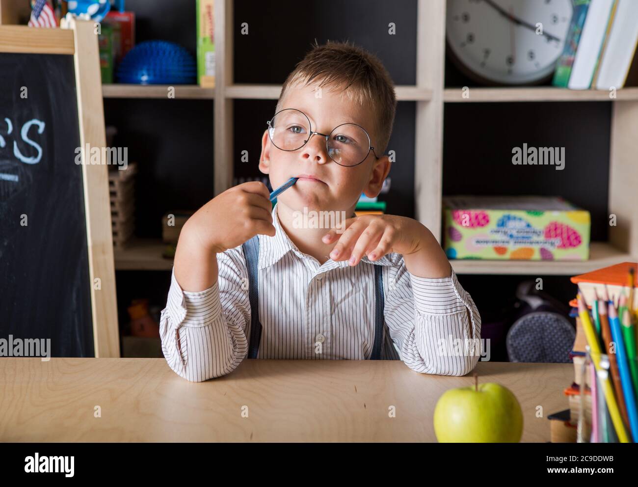 Drôle d'enfant dans des verres de l'école primaire. Étudiant et éducation à la maison.Journée des enseignants. Banque D'Images