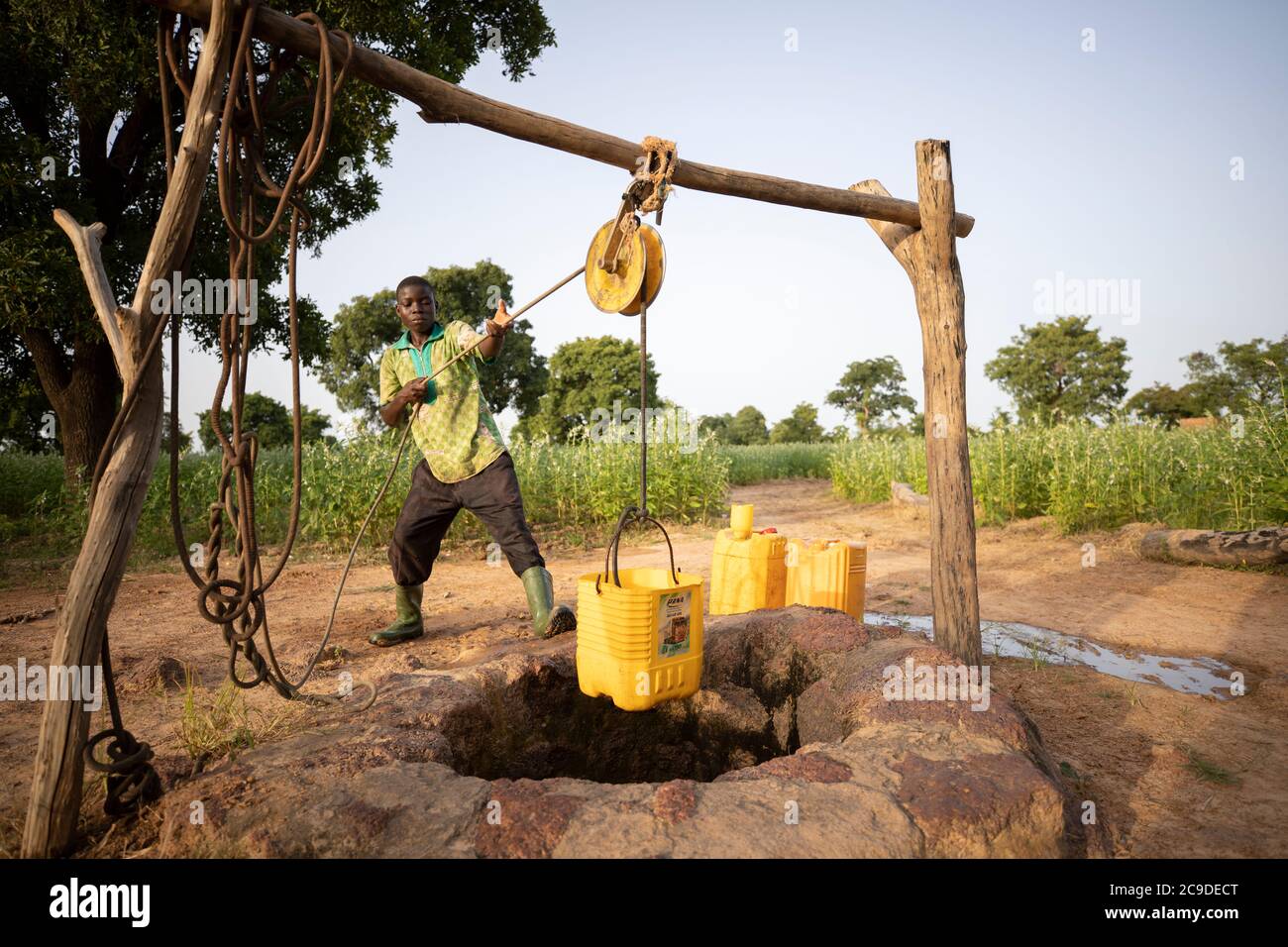 Un garçon puise de l'eau dans un puits de la province de Mouhoun, au Burkina Faso, en Afrique de l'Ouest. Banque D'Images