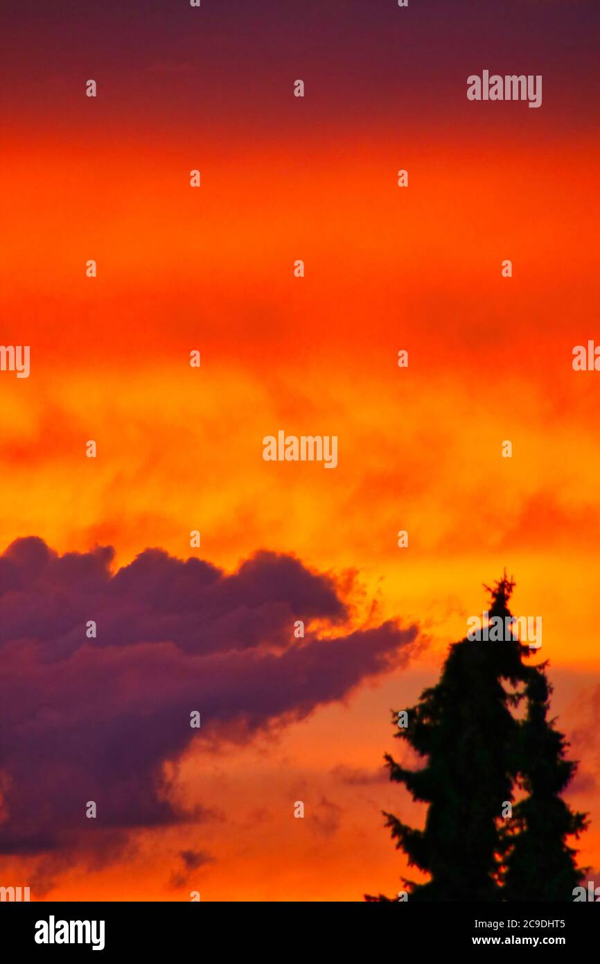 Le soleil bleu et orange émet une lumière dans le ciel avec un ciel nuageux Banque D'Images