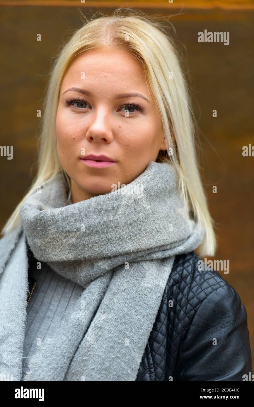 Jeune belle femme blonde contre vieux mur en métal rouillé Banque D'Images