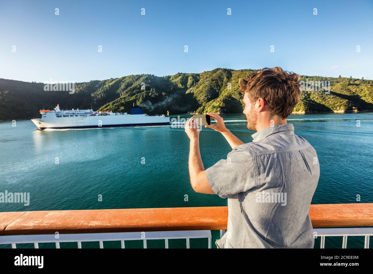 Voyage de croisière homme touriste prenant la photo de téléphone de bateau de ferry croisière sur la mer. Photos de tourisme pendant les vacances de passage de l'île de Nouvelle-Zélande à Marlborough Banque D'Images