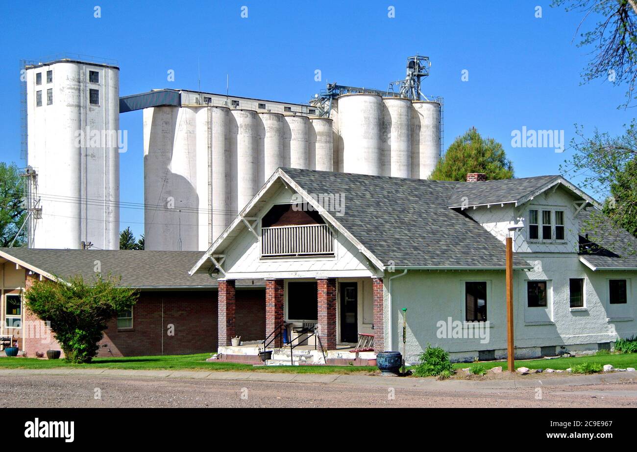 vue sur l'autoroute 30 à sidney, wyoming, de petite taille typique maison de la ville du wyoming avec ascenseur de grain en arrière-plan Banque D'Images