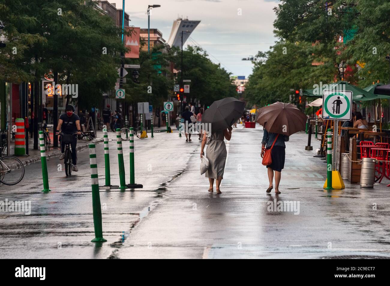 Montréal, CA - 30 juillet 2020 : personnes sur l'avenue Mont-Royal tenant des parasols sous la pluie et la tempête Banque D'Images