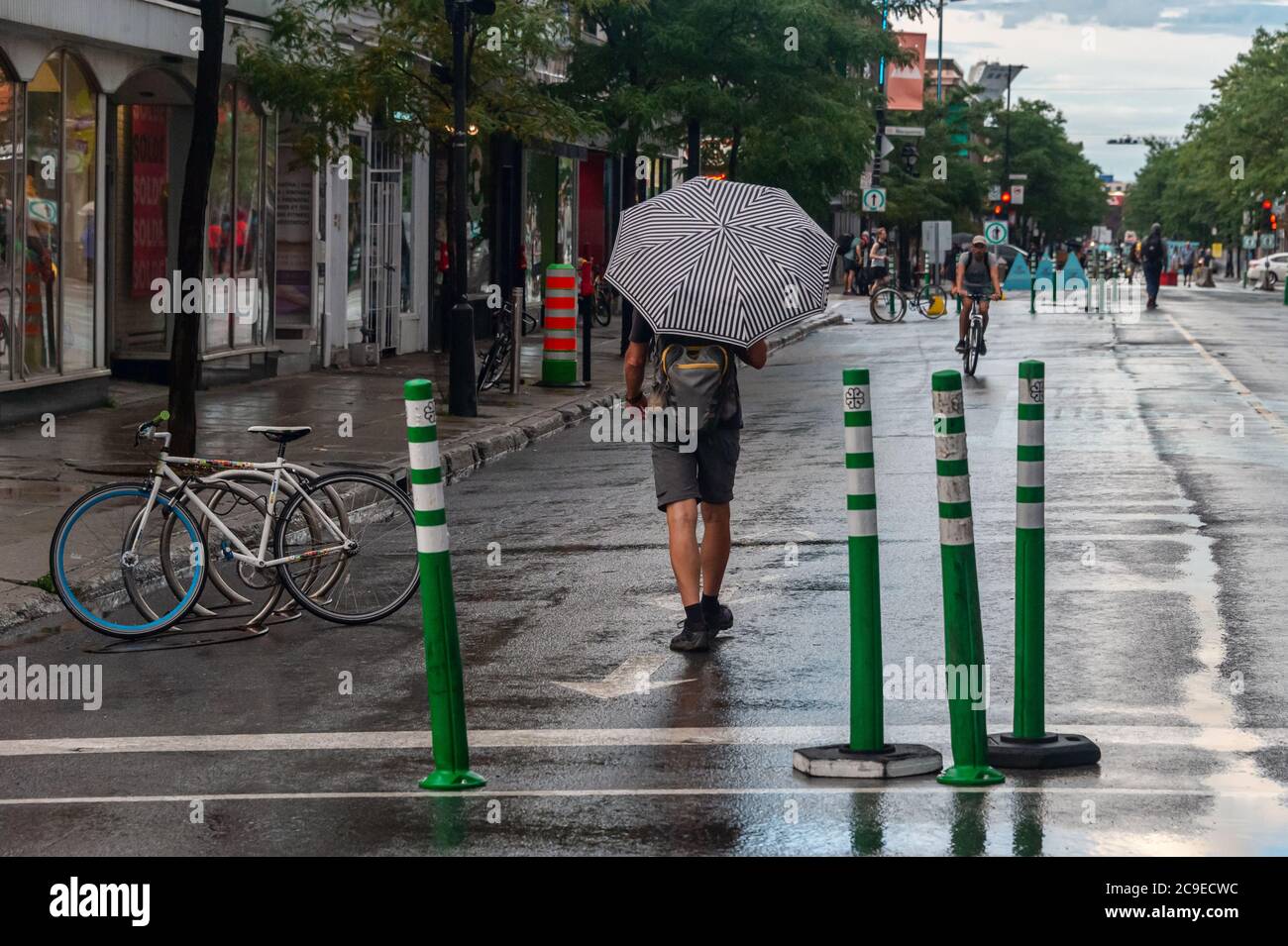 Montréal, CA - 30 juillet 2020 : un homme sur l'avenue Mont-Royal tenant un parapluie sous la pluie et la tempête Banque D'Images