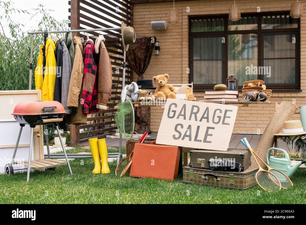Vente à l'extérieur de vieux articles tels que vêtements de dessus, appareil de gril, jouets et valises à l'ancienne en arrière-plan Banque D'Images