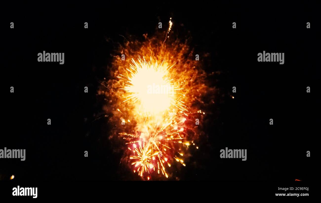 Gros plan image isolée d'un spectacle de feu d'artifice lorsque plusieurs feux d'artifice explosent en même temps. L'image présente une scène colorée sur le fond du ciel sombre de nuit Banque D'Images