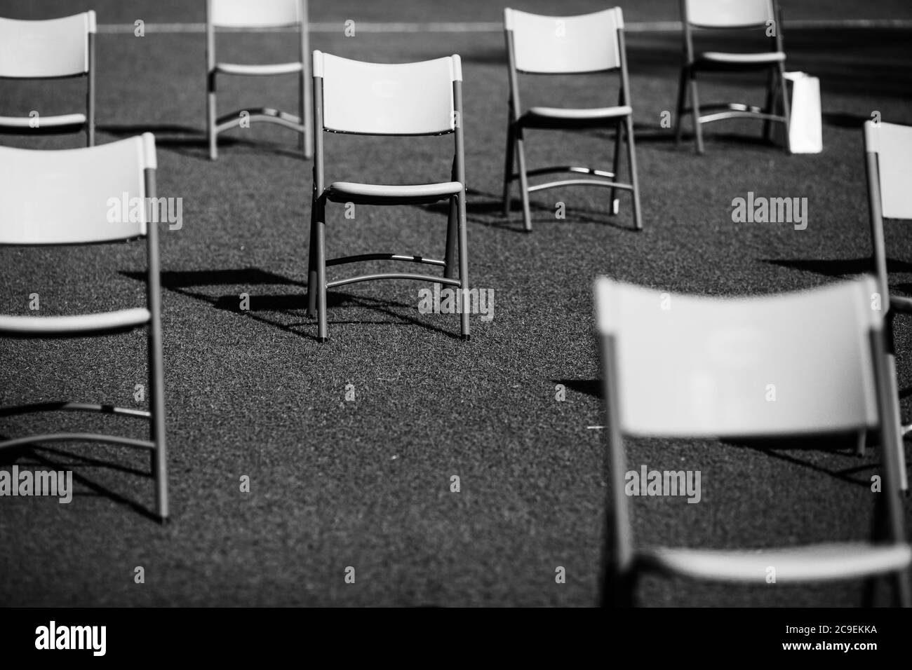 Se place l'un à côté de l'autre pour maintenir la distance sociale pendant l'épidémie de Covid-19 lors d'un événement en plein air sur le gazon d'un stade. Banque D'Images