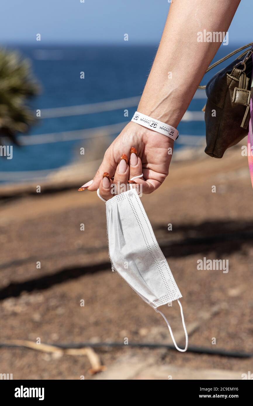 Costa Adeje, Tenerife, Iles Canaries, Espagne. 24 juillet 2020. Une femme touriste avec un GF Fanabe Hotel bracelet porte un masque facial qui est un requiremen Banque D'Images