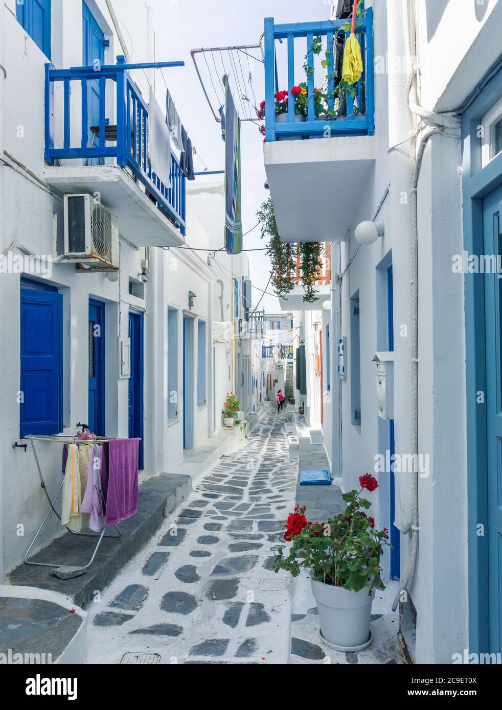 Maisons colorées, portes et fenêtres bleues et rouges et beaucoup de fleurs dans la vieille ville de l'île de Mykonos, Grèce. Banque D'Images