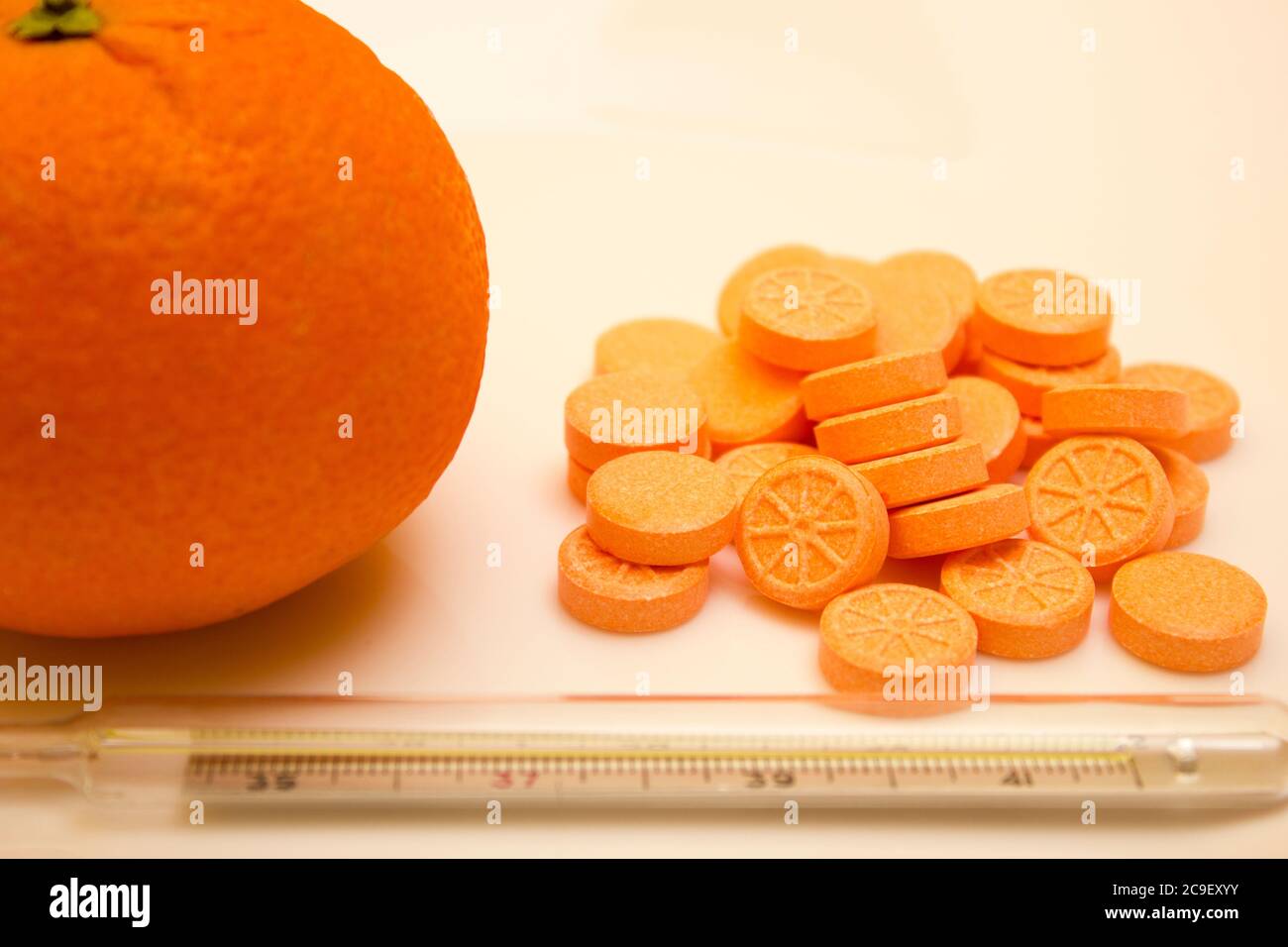 Thermomètre à mercure avec comprimés et orange sur fond blanc - vitamine, protection contre la grippe pendant la quarantaine, coronavirus, covid19 Banque D'Images