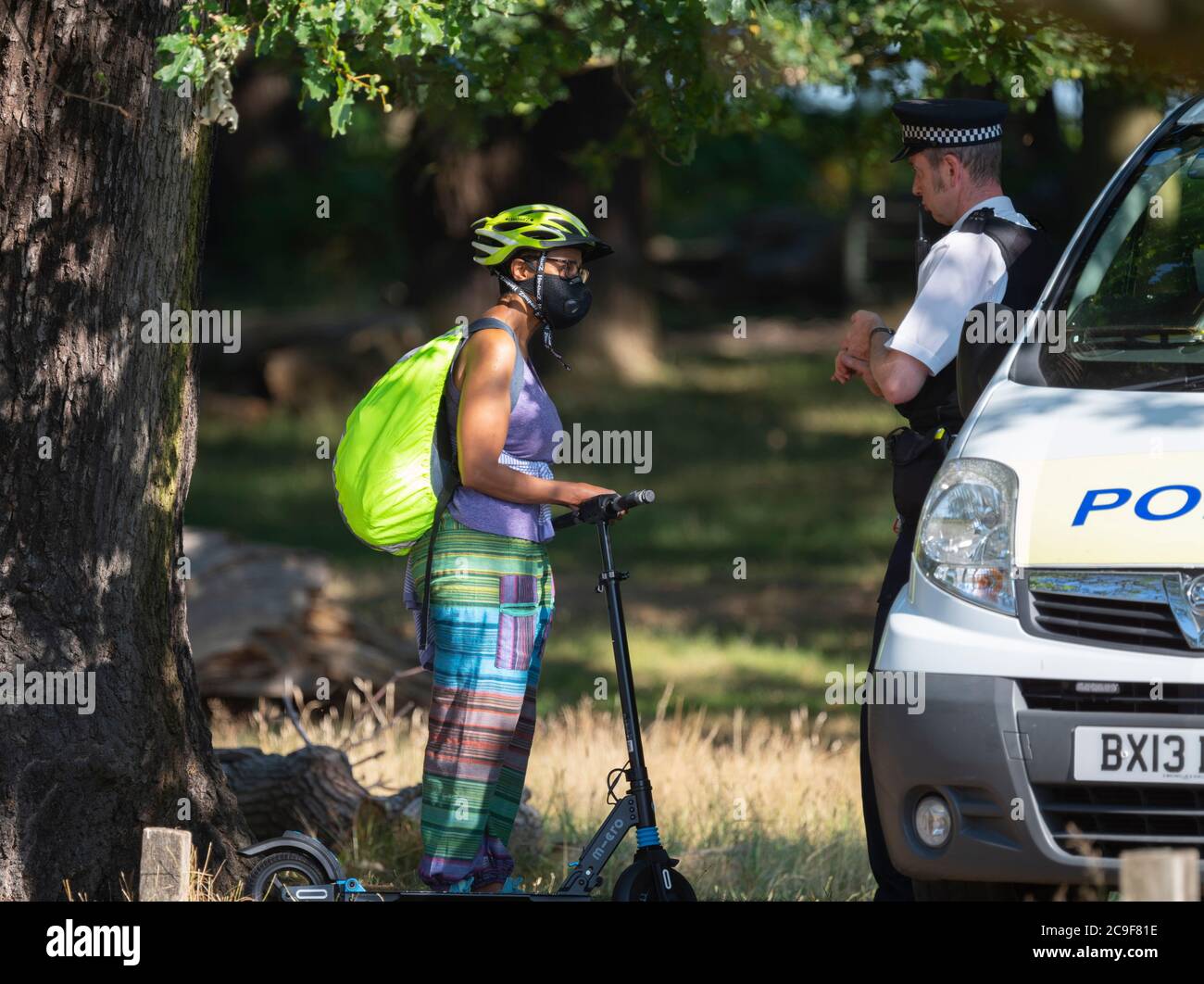 Richmond Park Londres, Royaume-Uni. 31 juillet 2020. Matin chaud à Richmond Park avec les marcheurs et les cyclistes à l'arrivée tôt appréciant le parc libre de circulation au début d'une journée pour atteindre 33 degrés. L'accès aux véhicules est limité à seulement trois parkings sans circulation dans le parc Royal. Un policier parle avec un scooter électrique masqué. Crédit : Malcolm Park/Alay Live News. Banque D'Images