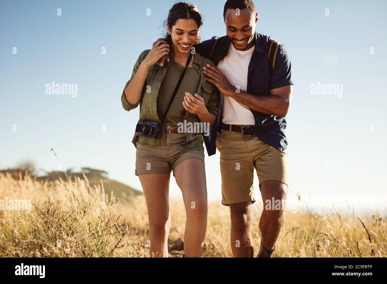 Couple pour une randonnée pédestre par une journée ensoleillée. Couple en vacances à pied ensemble sur la prairie. Banque D'Images
