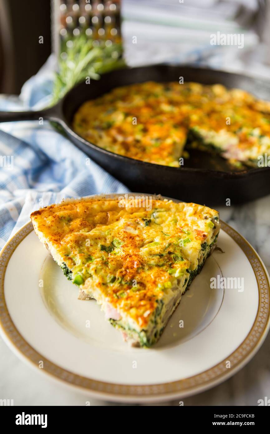 Frittata maison fraîche cuite dans une casserole en fonte avec découpe en tranches Banque D'Images