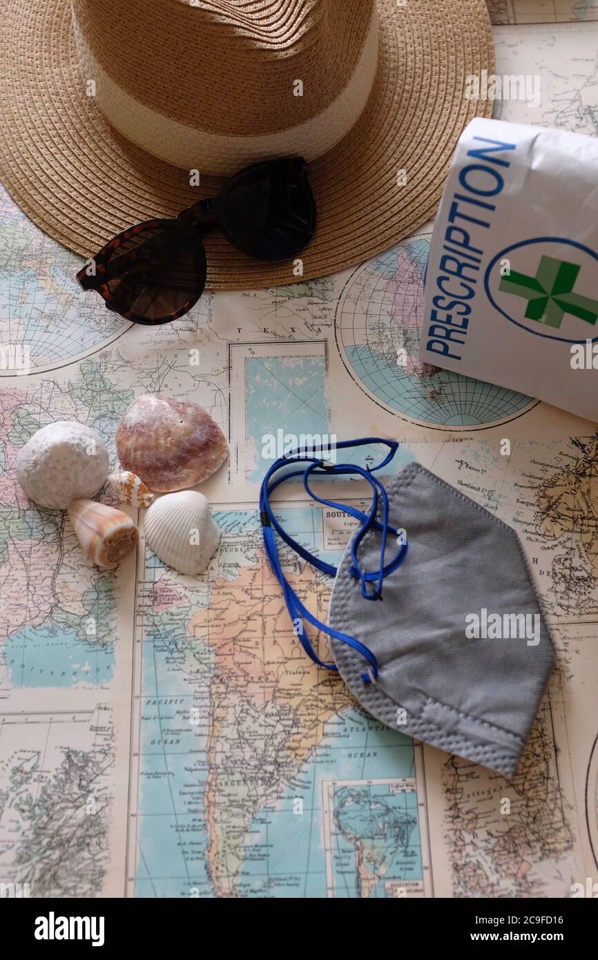 Masque Covid, voyage de vacances, meds sur la carte du monde avec espace de copie Banque D'Images