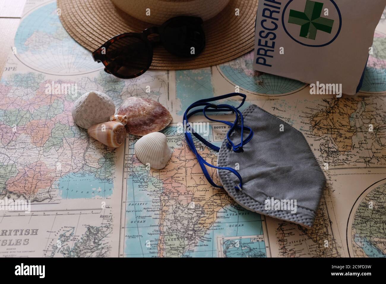 Masque Covid, voyage de vacances, meds sur la carte du monde avec espace de copie Banque D'Images