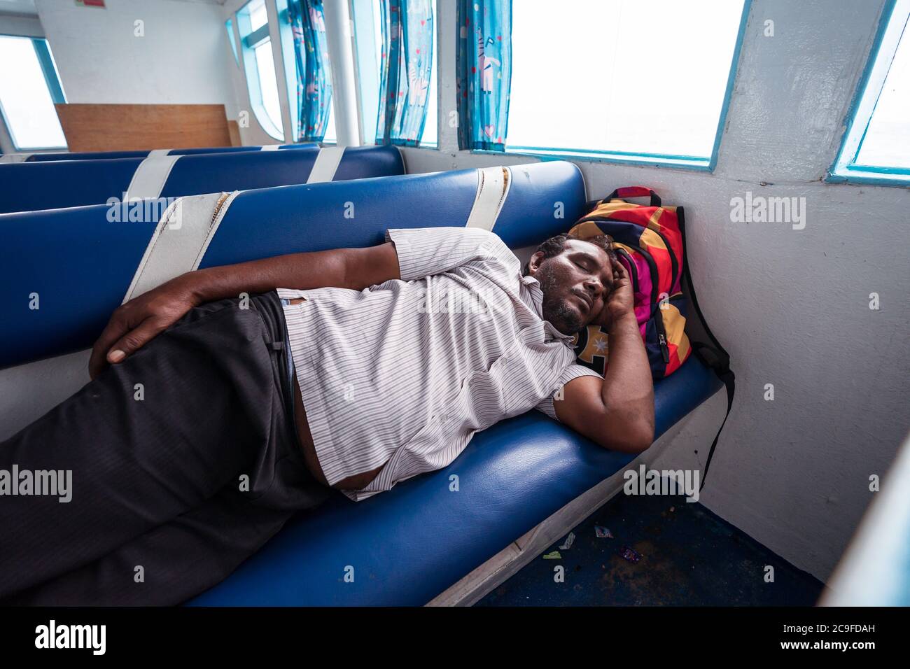 Bodufolhudhoo / Maldives - 17 août 2019: Homme dormant dans le siège de bateau de ferry tout en traversant l'océan Indien à Rasdhoo atoll Banque D'Images