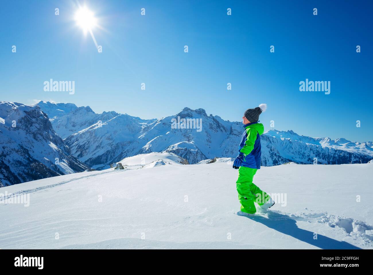 Garçon dans l'école de randonnée pédestre marcher sur la neige vierge profitant de la vue du sommet d'activité d'hiver concept Banque D'Images