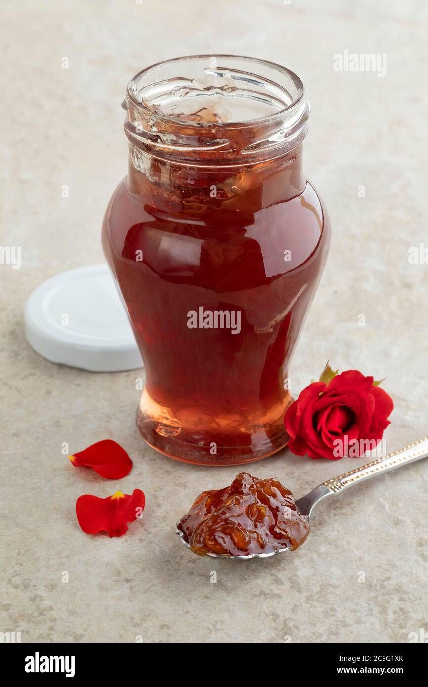 Pot en verre avec confiture de pétales de rose maison et une rose rouge fraîche Banque D'Images