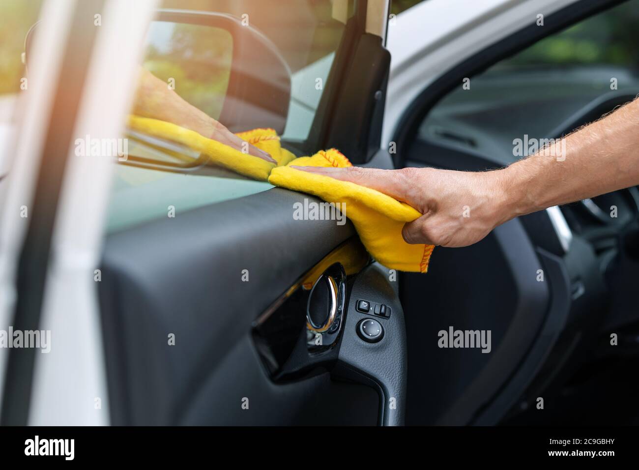 main avec un chiffon en microfibre pour nettoyer l'intérieur de la voiture Banque D'Images