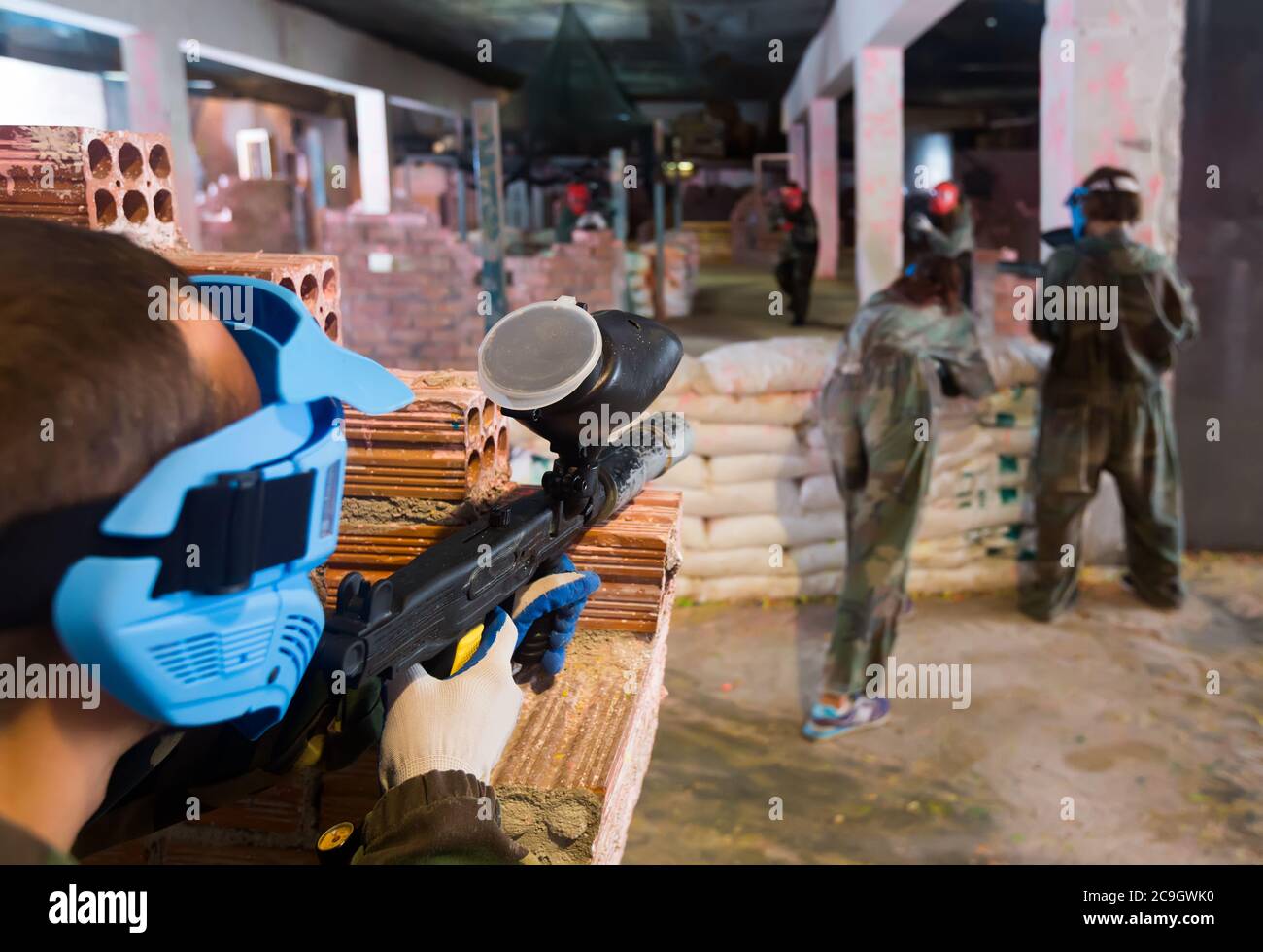 Les rivaux ciblent les ennemis derrière les barricades sur le champ de bataille du paintball club. Banque D'Images