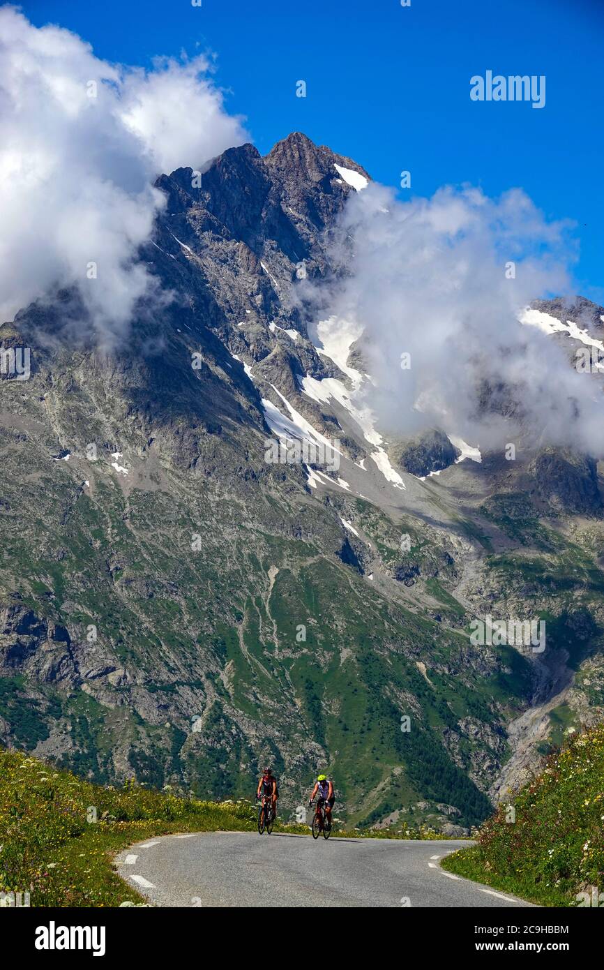 Deux cyclistes sur le col de Galibier et les pics alpins, Parc national des Ecrins, Alpes françaises, France Banque D'Images
