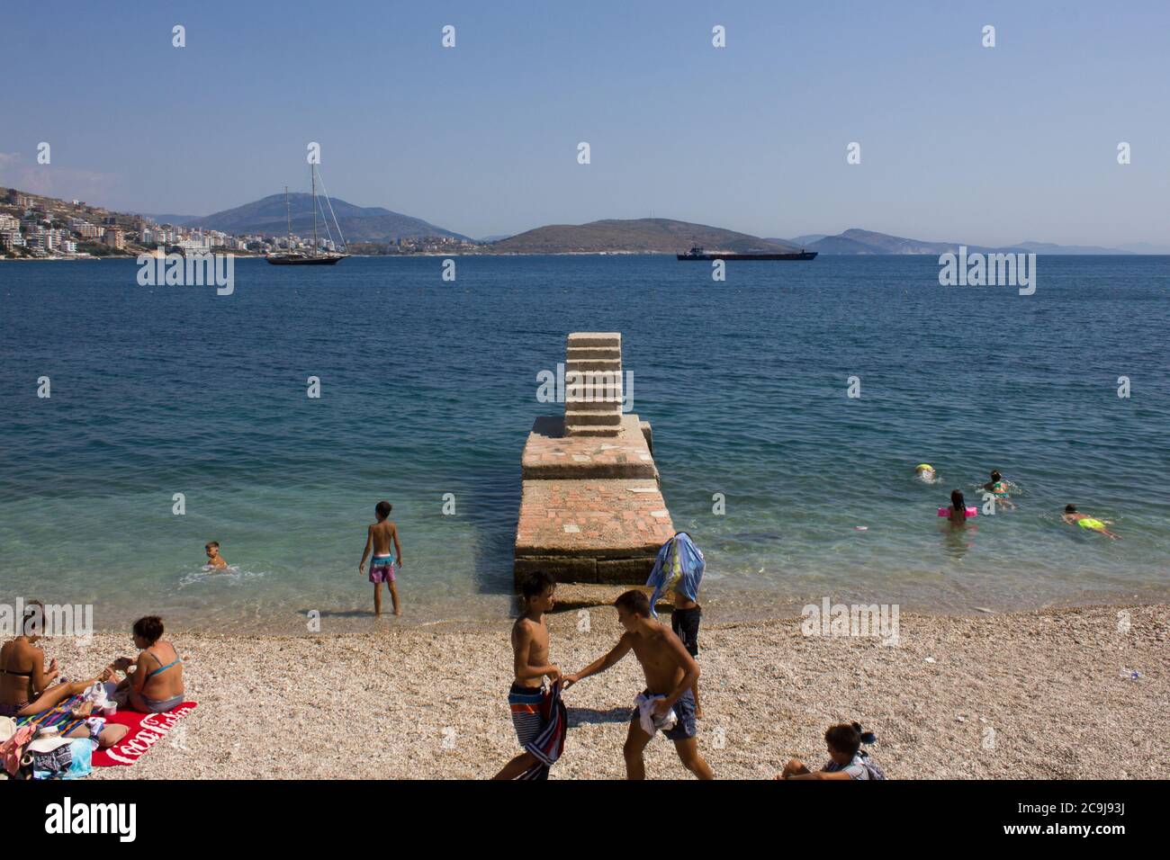 Saranda / Albanie - juillet 2020: La plage publique de Saranda avec des escaliers en pierre est pleine de vacanciers en vacances comme les restrictions coronavirus sont levées Banque D'Images