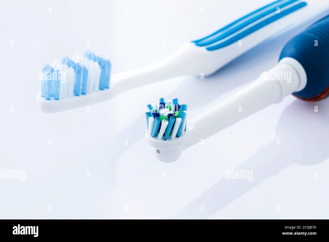 Brosses à dents électriques et manuelles sur fond blanc. Banque D'Images
