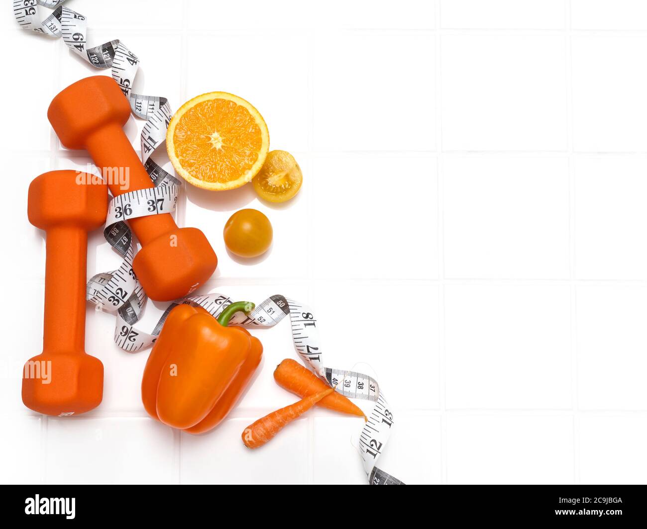 Fruits et légumes sains avec des haltères, photo en studio. Banque D'Images