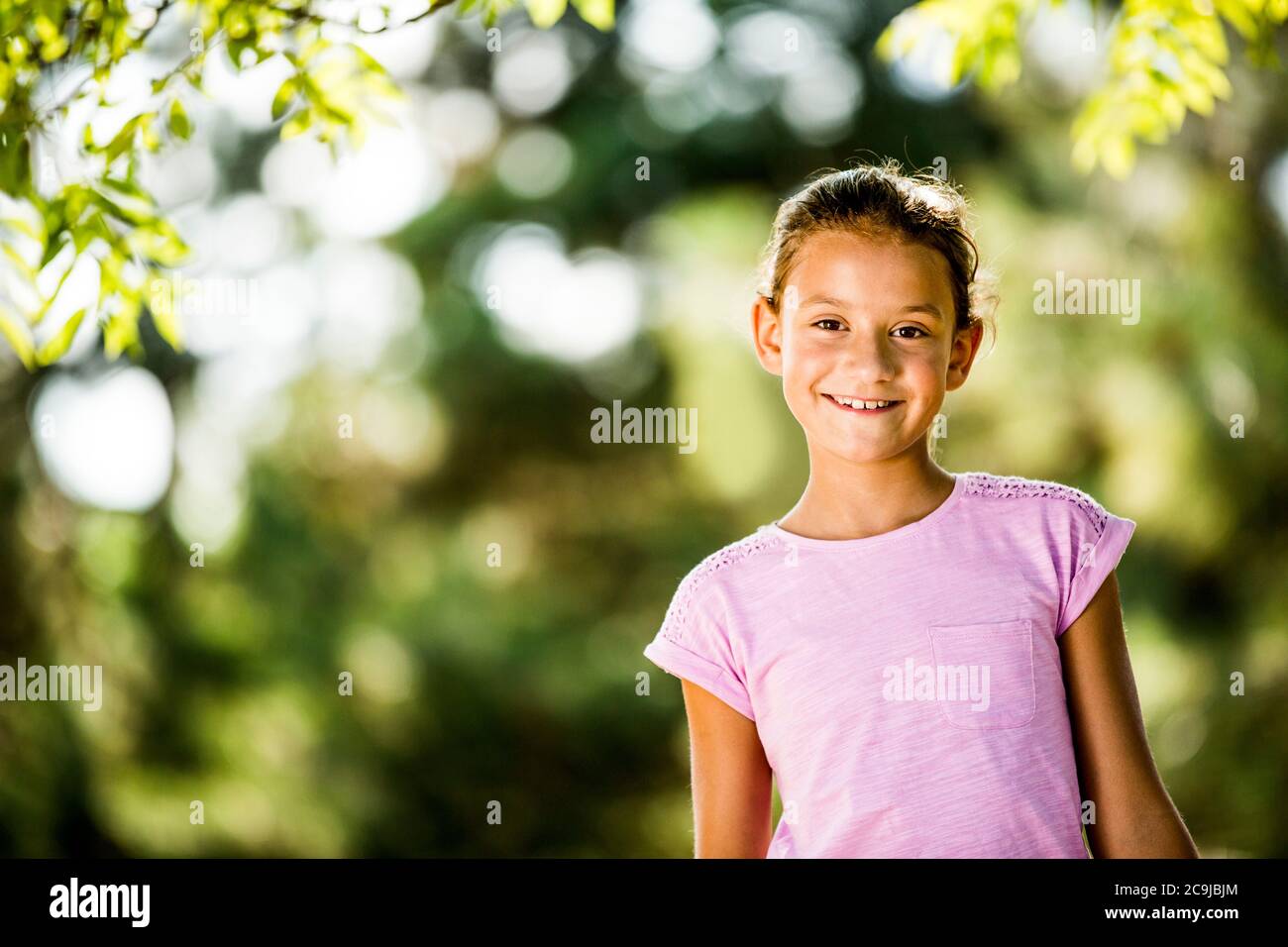 Garçon souriant dans le parc, portrait. Banque D'Images