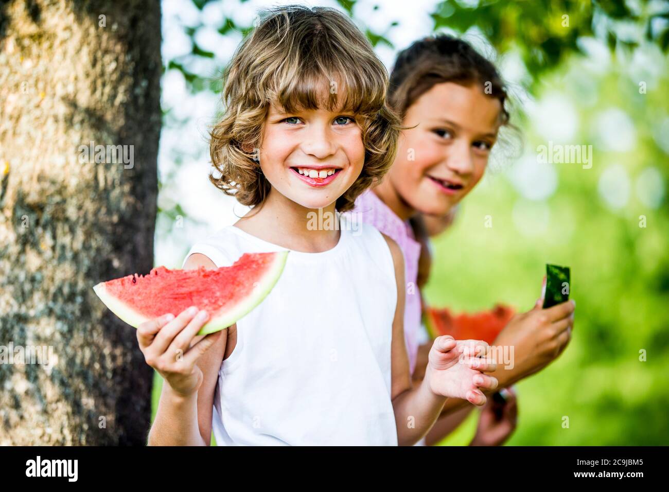 Enfants qui mangent de la pastèque dans le parc. Banque D'Images