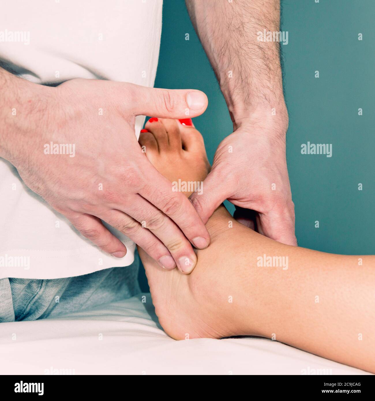 Physiothérapeute examinant la cheville entortillée d'une patiente. Banque D'Images