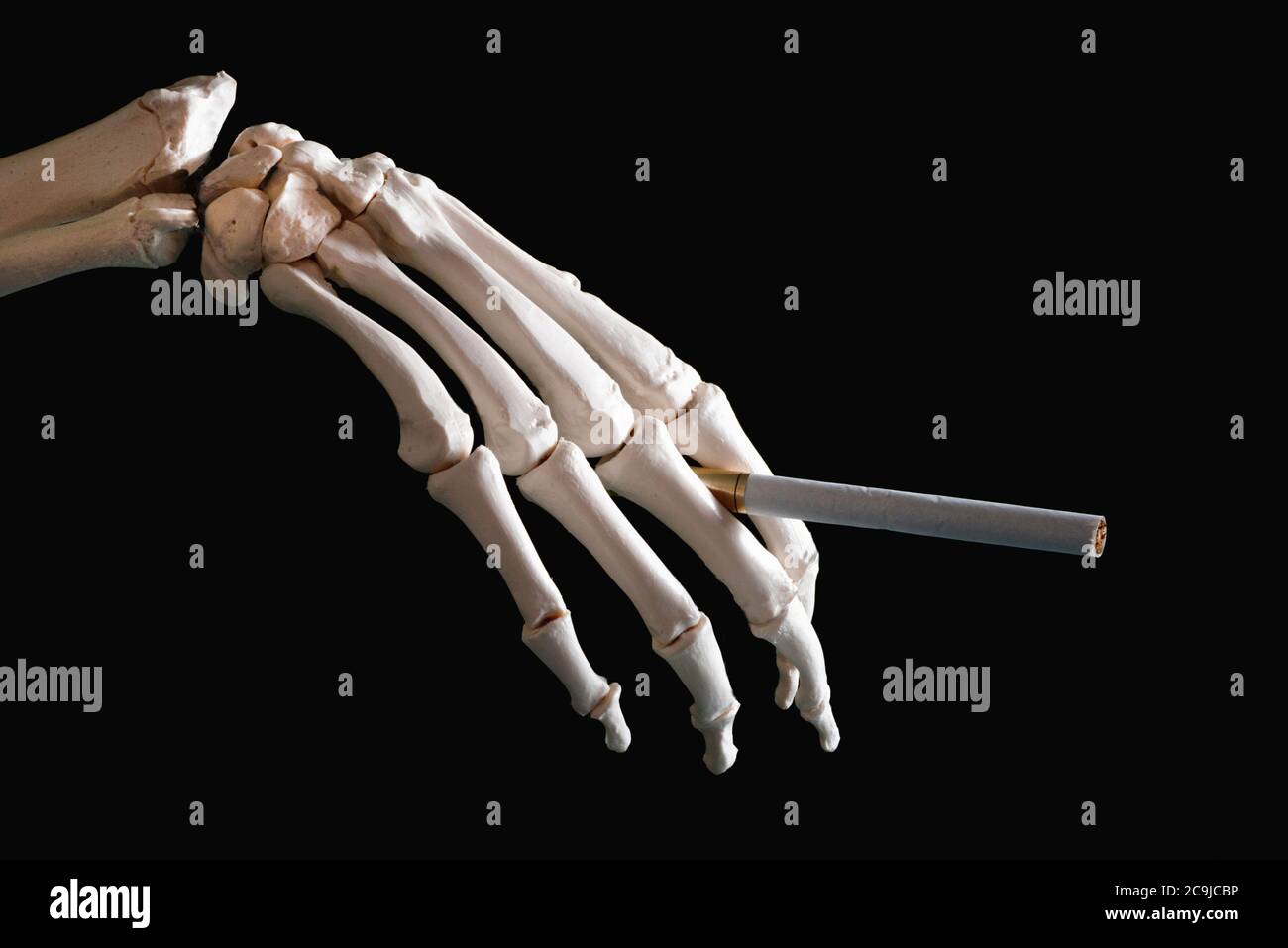 Squelette main tenant la cigarette. Banque D'Images