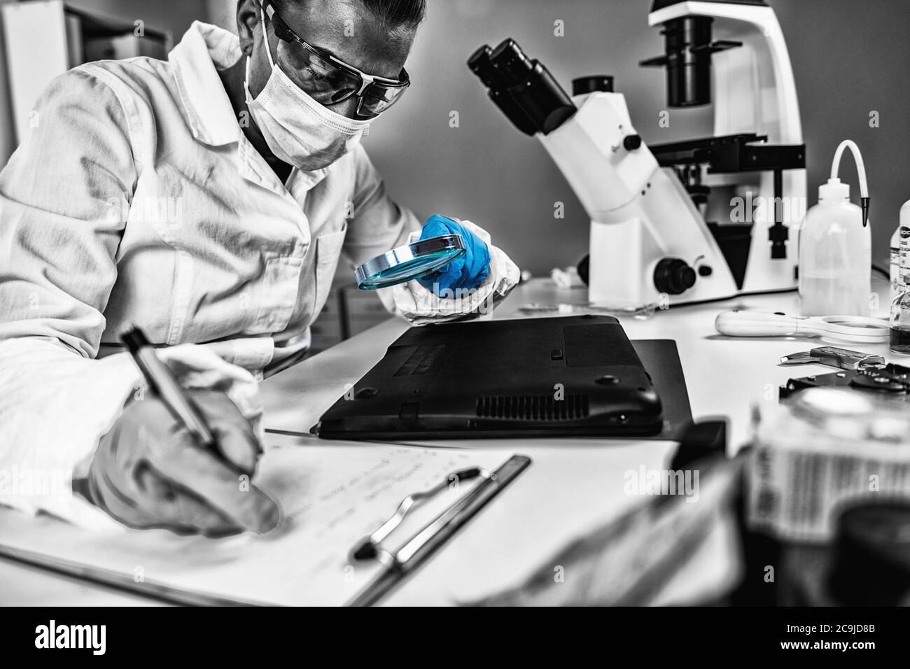 Données médico-légales. Analyste judiciaire examinant un ordinateur portable. Banque D'Images