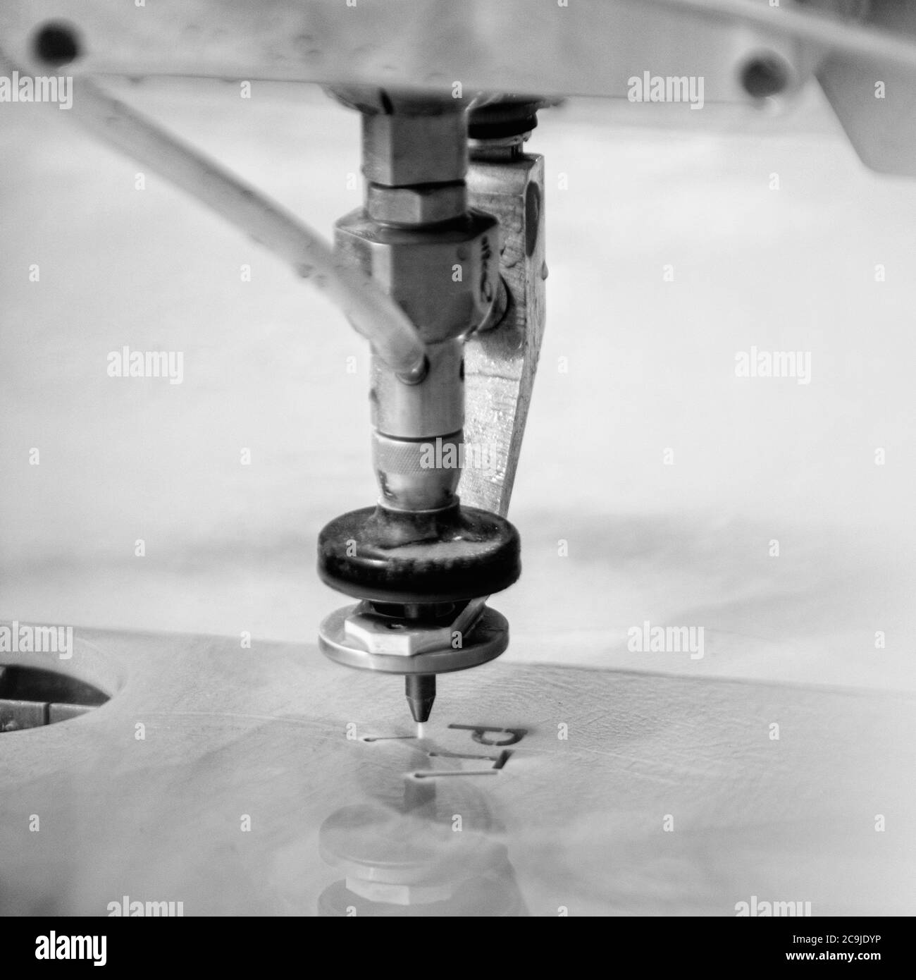 Machine de découpe CNC à jet d'eau utilisant une haute pression pour percer à travers une tôle épaisse. Écrire des lettres pour démontrer la précision et la puissance. Banque D'Images