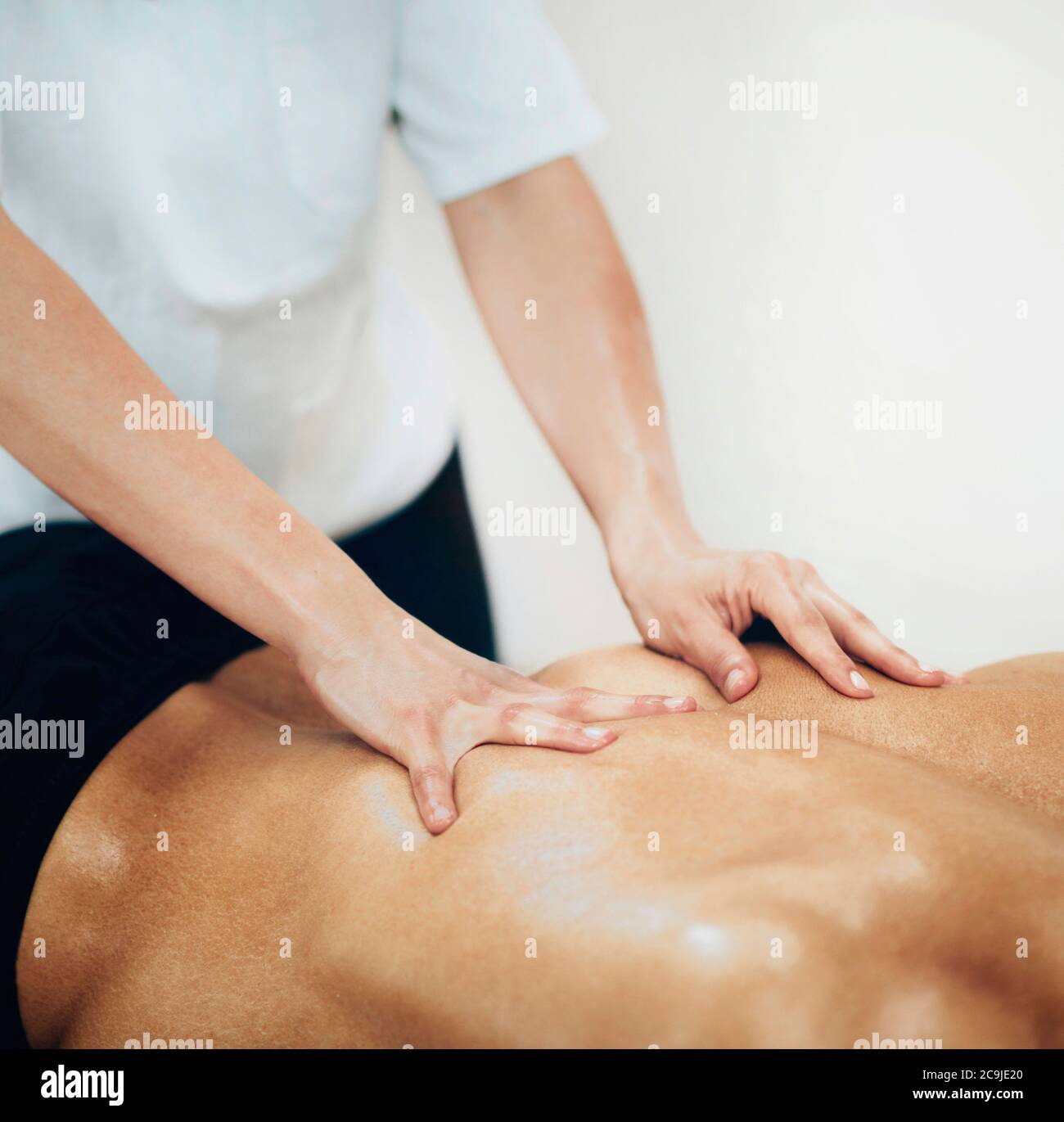 Massage sportif. Un physiothérapeute massant le dos de l'homme. Banque D'Images