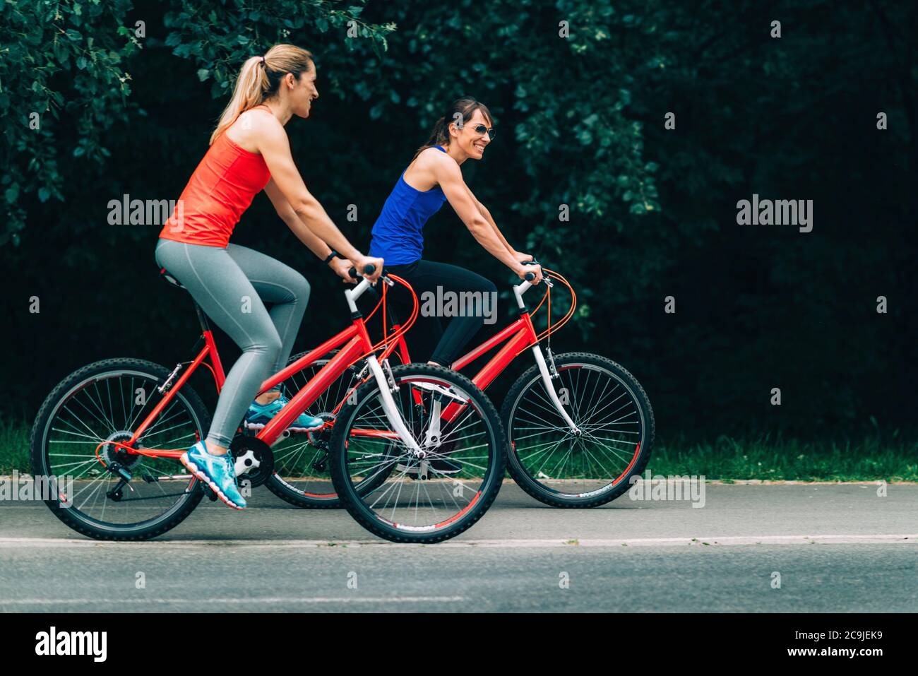 Des amies qui se rassemblent en vélo dans le parc. Banque D'Images