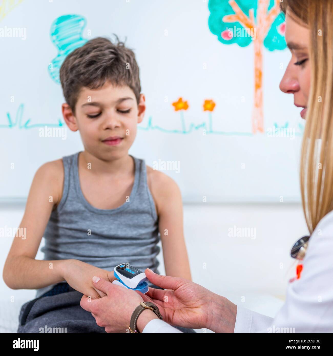 Pédiatre mesurant l'oxygène dans le sang et le rythme cardiaque avec l'oxymètre de pouls. Banque D'Images