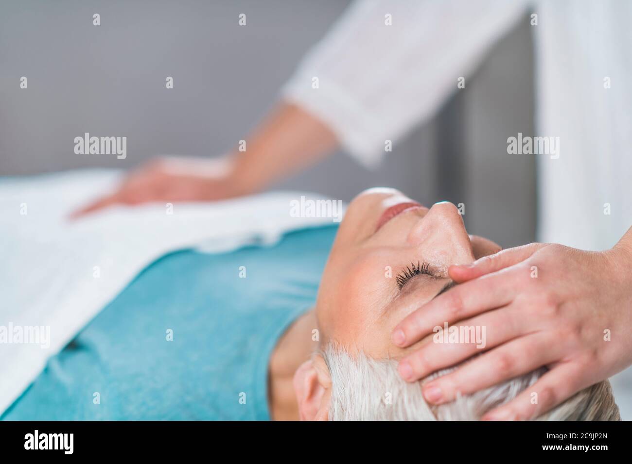 Marma praticien de thérapie équilibrant la tête du patient et l'estomac chakras. Banque D'Images