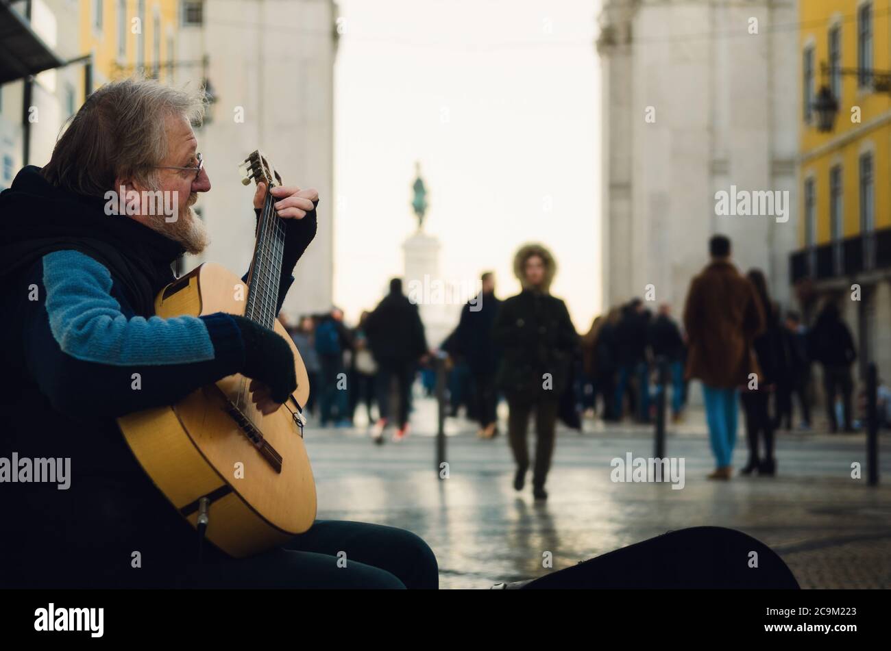 LISBONNE, PORTUGAL - 3 FÉVRIER 2019 : portait sombre moody d'un ancien interprète de rue jouant de la guitare en hiver sur Rua Augusta, rue commerçante principale o Banque D'Images