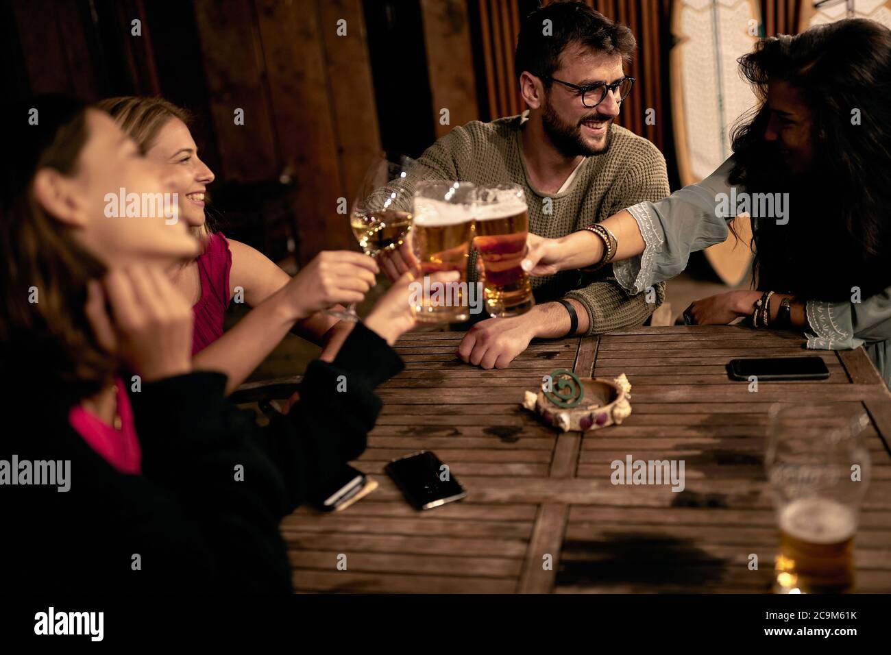 Personnes assises en train de boire un verre en terrasse en souriant et ...