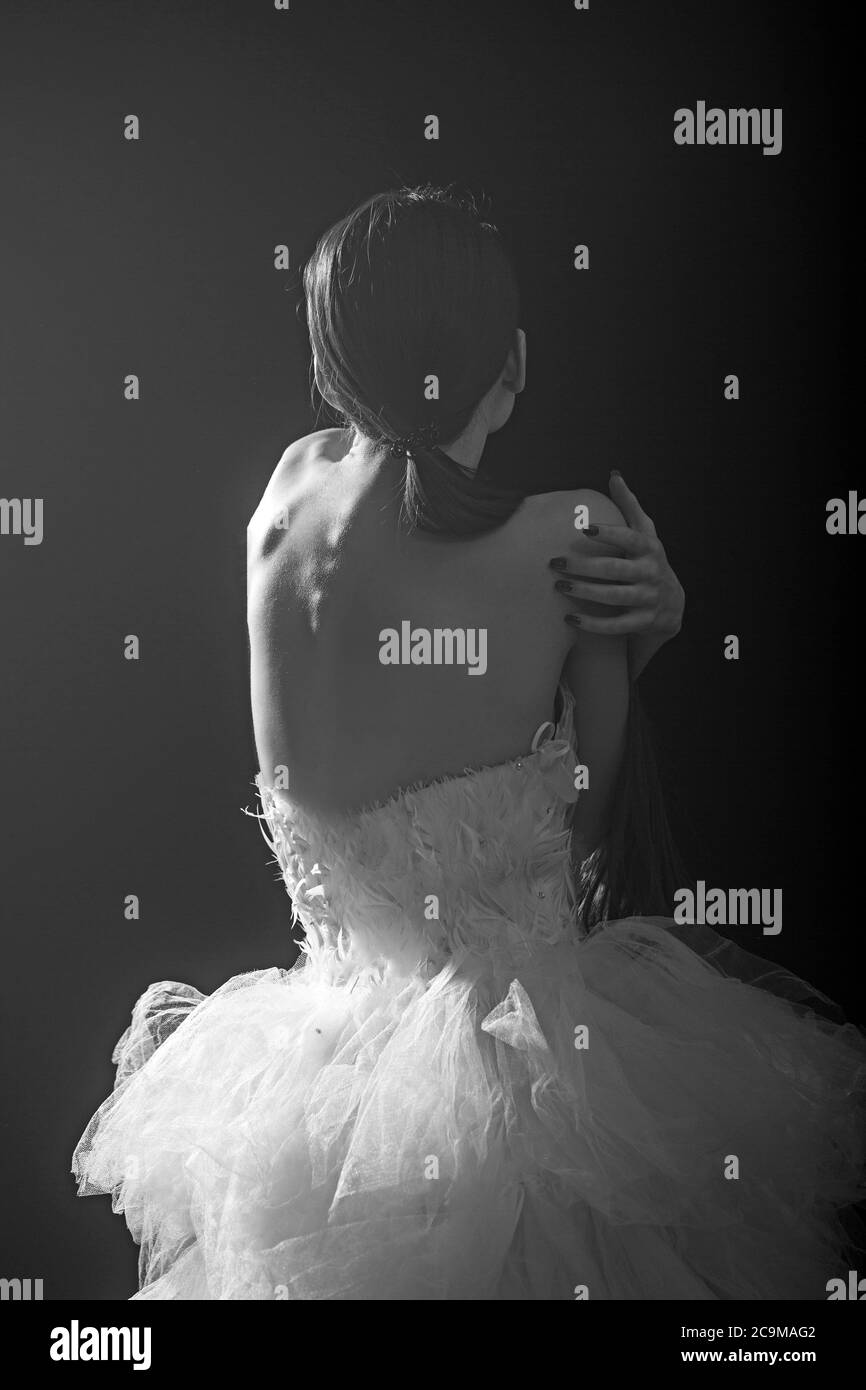 Jeune danseuse magnifique posant en studio sur fond sombre. Banque D'Images
