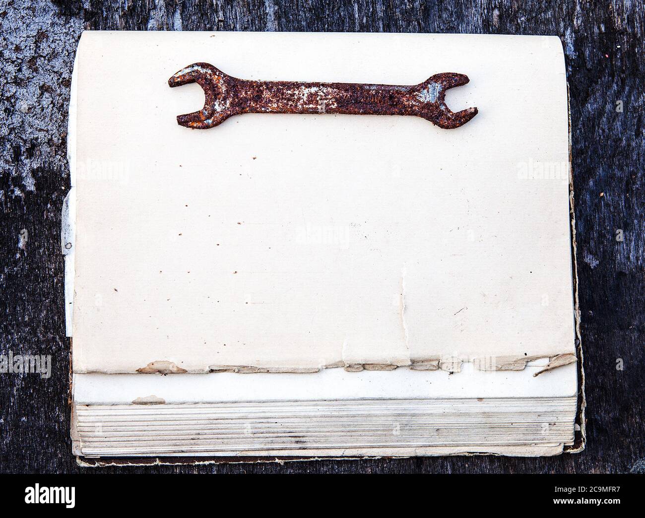 Old Rusty Tool sur l'ancien livre et le fond en bois clôture Banque D'Images