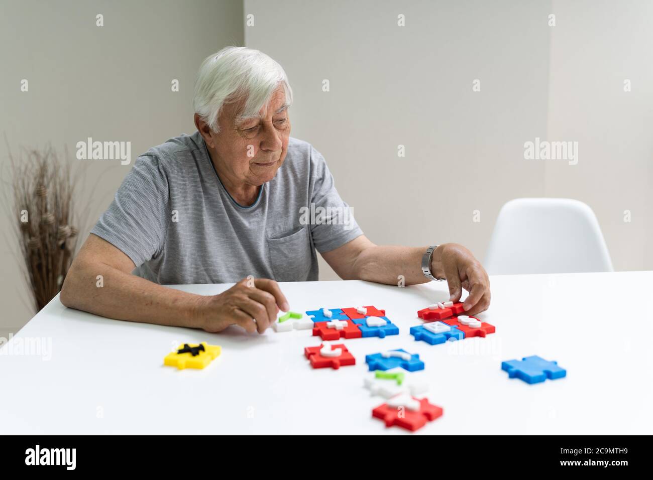 Homme aîné jouant Jigsaw Puzzle sur la table Banque D'Images