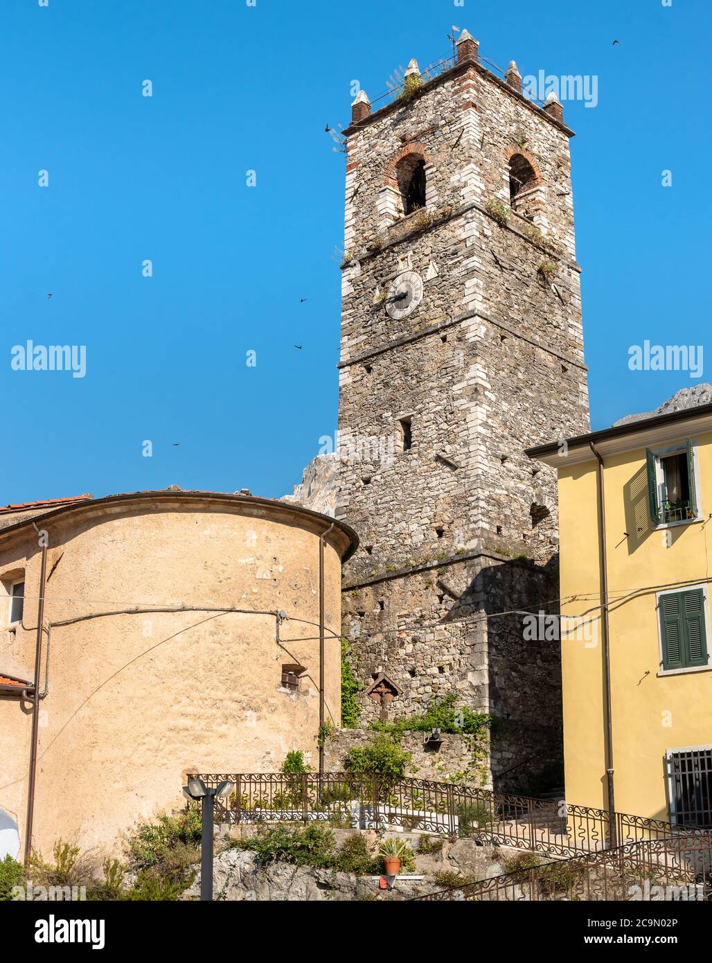 Vue sur le clocher de l'église Sant Bartolomeo dans l'ancien village de Colonnata et les Alpes Apuanes avec des carrières de marbre en arrière-plan, province de Massa Banque D'Images
